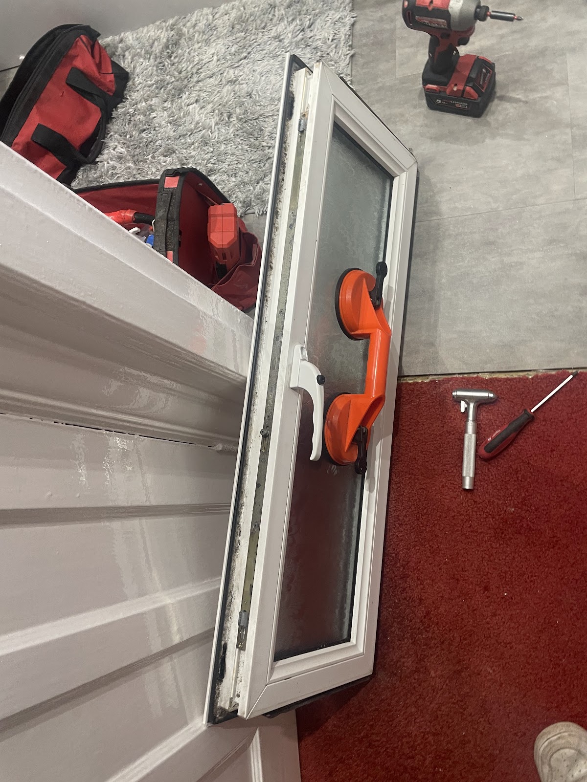 Sealed window unit lifted out with suction grips during a glazing repair